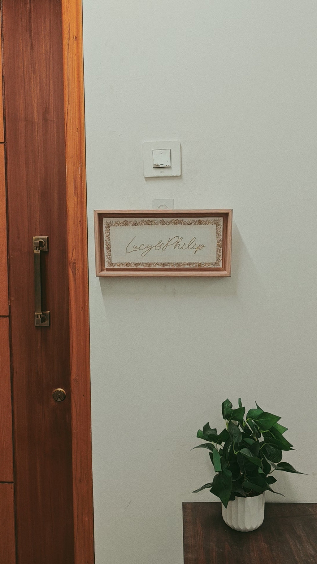 custom name plate with gold embroidery and light wooden frame